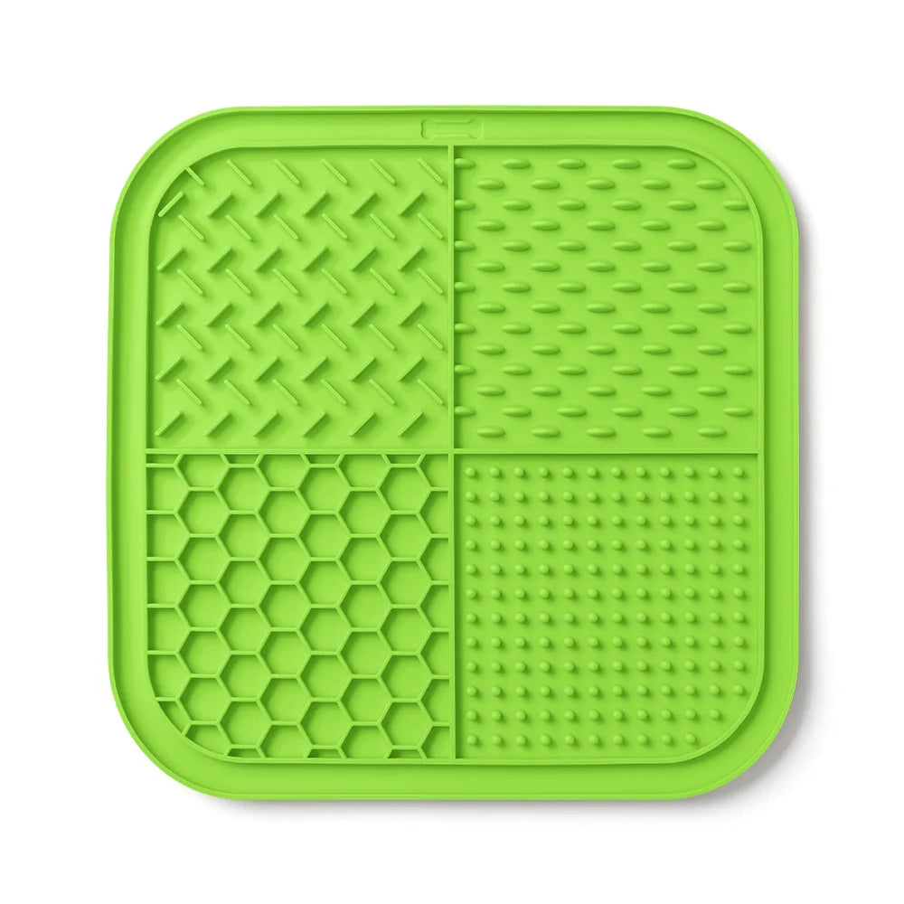 A bright lime green silicone lick mat for pets with a grid pattern and suction cups.