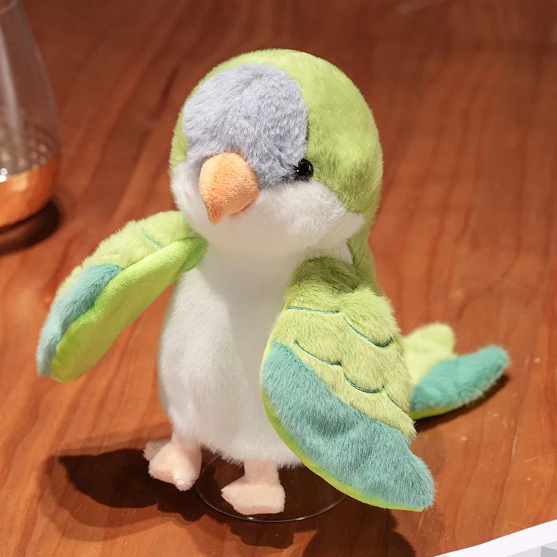 A soft, light green and white plush parrot hand puppet toy with orange beak sitting on a clear stand.