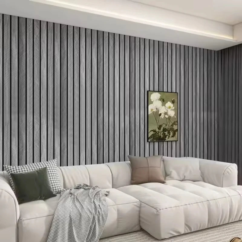 A modern living room wall decorated with vertical gray wood grain wallpaper and a white sofa.