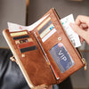 A brown leather wallet with a gold clasp is shown open, displaying various credit cards and an ID card.