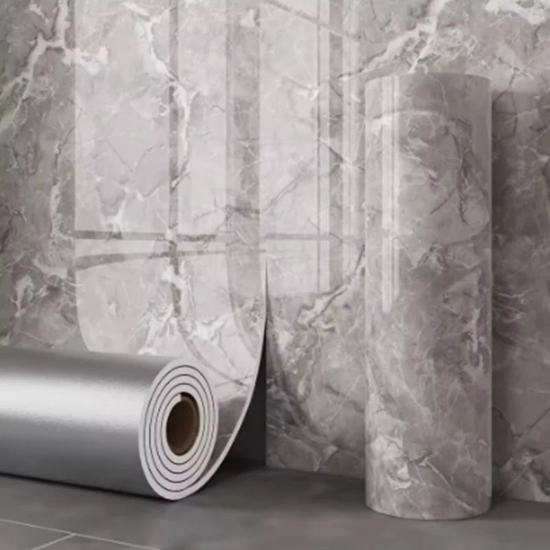 Roll of self-adhesive marble wallpaper showing a gray and white marbled pattern against a textured wall.