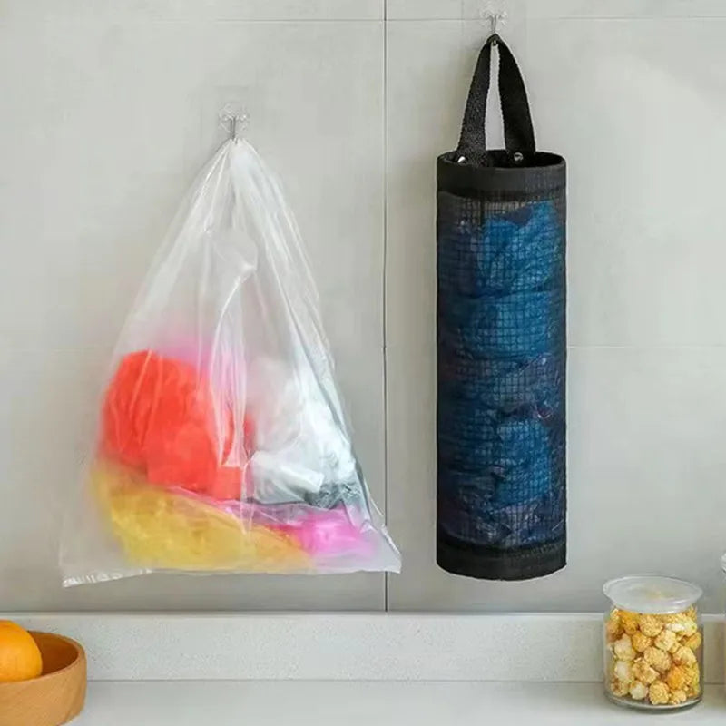 Wall-mounted plastic bag dispenser organizer with colorful plastic bags hanging on a white tiled wall.