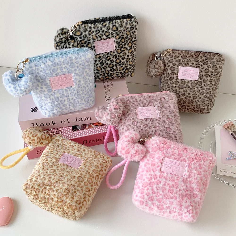A collection of pink, beige, and leopard print cosmetic bags and makeup organizers displayed on a white surface.