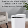 A white touchless motion sensor trash can with a black lid sitting on a wooden floor.
