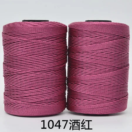 Spool of pink 3-ply polyester knitting yarn for crochet and hand crafts
