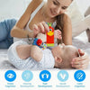 A woman is gently interacting with a baby using soft wrist rattles and foot finder socks for development.