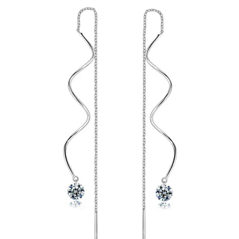 Un par de elegantes pendientes colgantes de circonita cúbica con cadena plateada y piedra brillante.