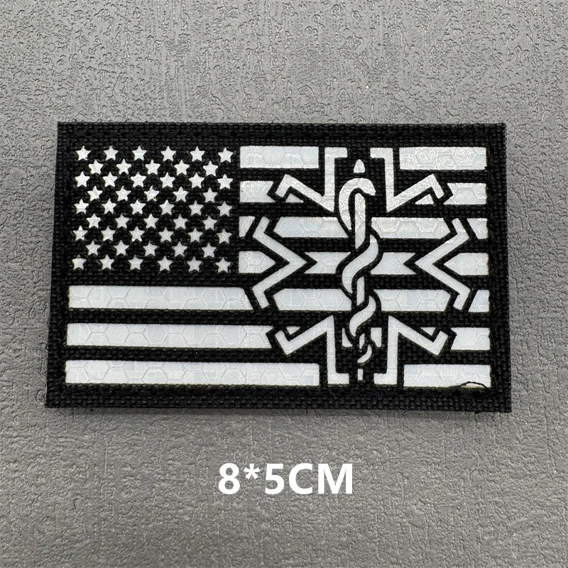 Black embroidered patch featuring a white American flag design with a stylized snake motif.