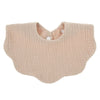 A light beige knitted baby bib in a bandana style with a rounded neckline and a small button closure.