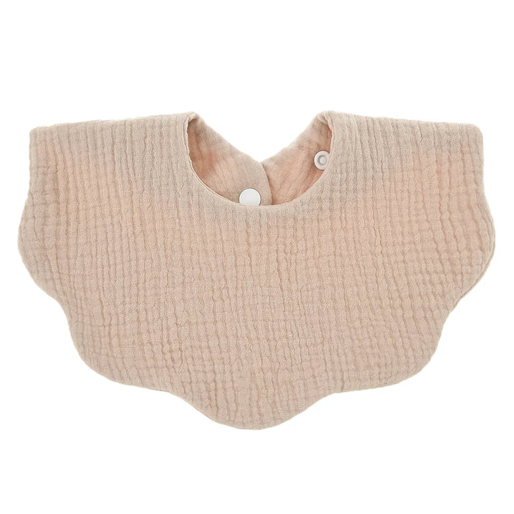 A light beige knitted baby bib in a bandana style with a rounded neckline and a small button closure.