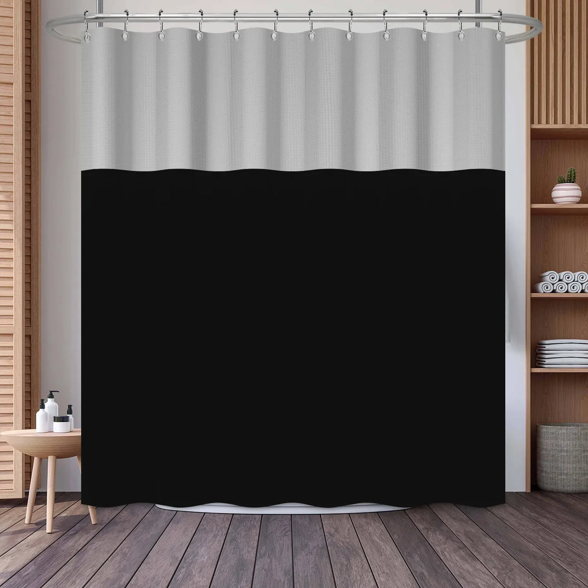 A black shower curtain with a white stripe pattern hanging from a metal rod.