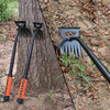 A black stainless steel weeding shovel and rake are shown against a tree trunk in a natural outdoor setting.