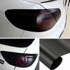 Close-up view of a matte smoke vinyl wrap film applied to a car's headlight and taillight.
