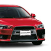 A close-up of a red car's front grille with an aluminum license plate frame featuring a black and grey camouflage finish.