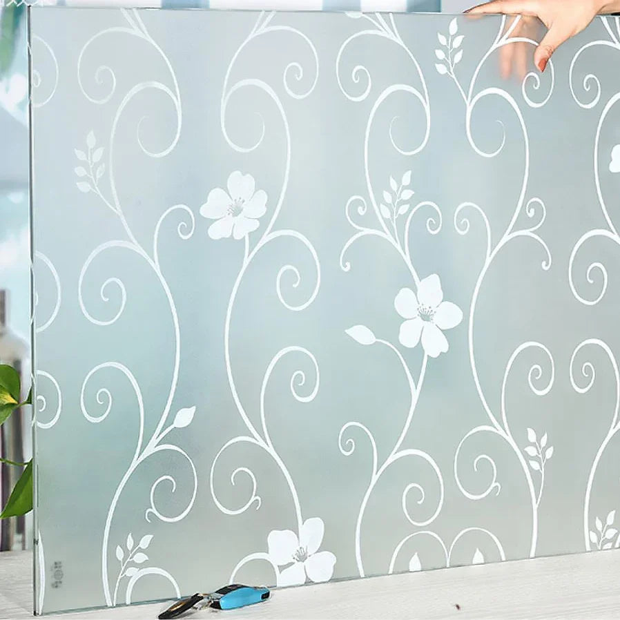 Frosted privacy window film with a white swirling floral pattern applied to glass.