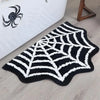 A black and white decorative rug featuring a spider web pattern with a ghost design.