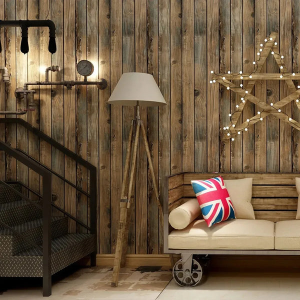 A rustic interior featuring a wooden staircase, wall paneling, and a lamp with a beige shade.