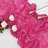 Pink ruffled cotton gauze table runner with gold metal utensils and light pink flowers