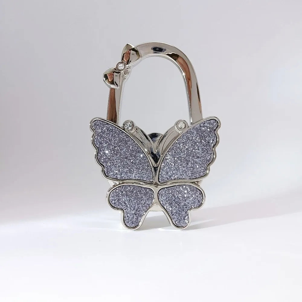 Silver foldable butterfly shaped handbag hook with glitter accents