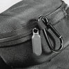 Close-up of a black woven fabric travel case with a zipper and metal clasp.