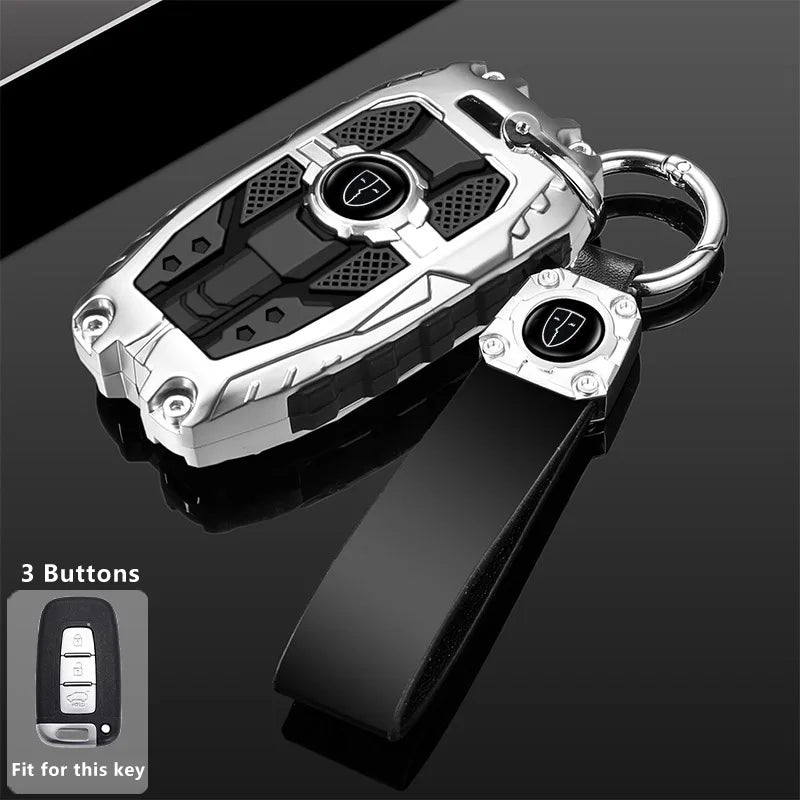 Silver protective key fob cover with a black strap and three buttons shown against a dark background.