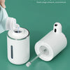 A white touchless automatic soap dispenser is shown with a pump mechanism and a dispensing nozzle on a green background.