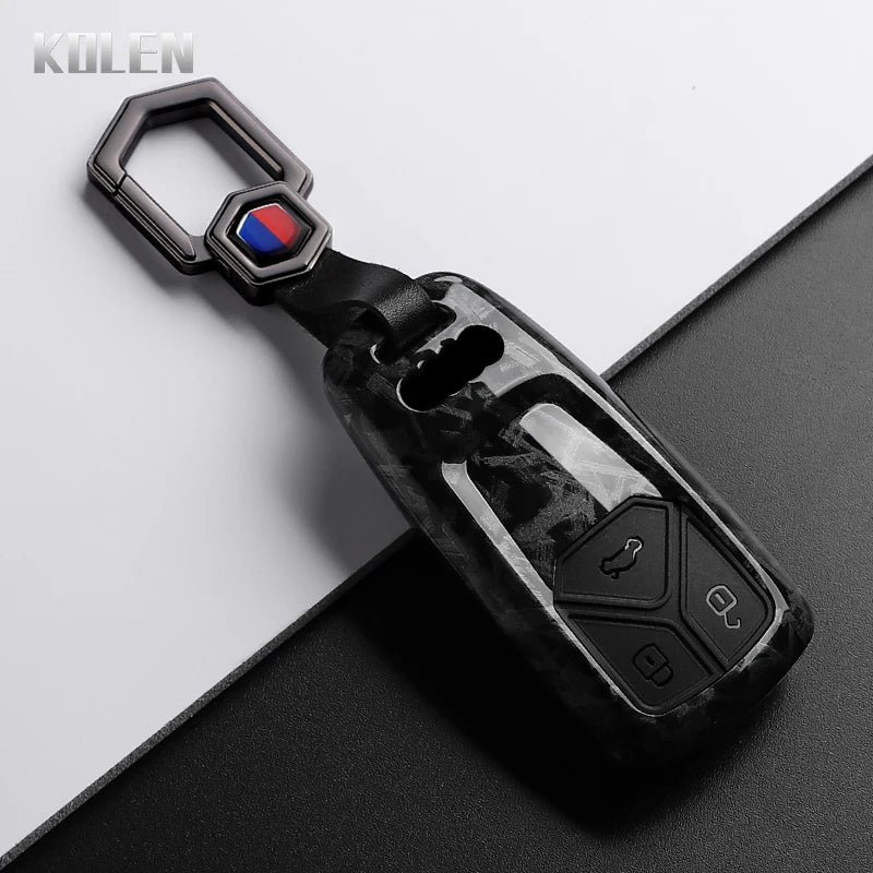 A black carbon fiber style key fob cover with a silver loop and a red, white, and blue emblem.
