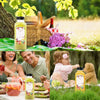 A collection of reusable plastic juice bottles with tamper-evident caps displayed in a natural, outdoor setting.