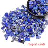 A pile of vibrant blue lapis lazuli crystal stone chips and tumbled stones.