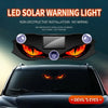 LED solar warning light featuring a demon eye design installed on a car's front grille.
