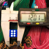 A digital caliper measuring 12.01 mm next to a white plastic dice set.
