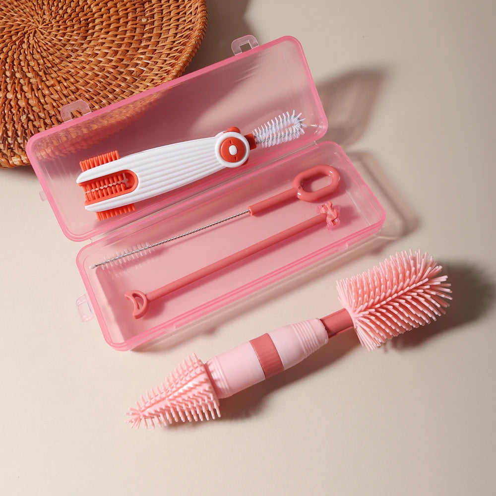 A pink silicone baby bottle cleaning set with three brushes is displayed in an open plastic case.