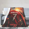 Rotes Fußballtrikot mit dem Namen RONALDO und der Nummer 7 auf einer Decke.