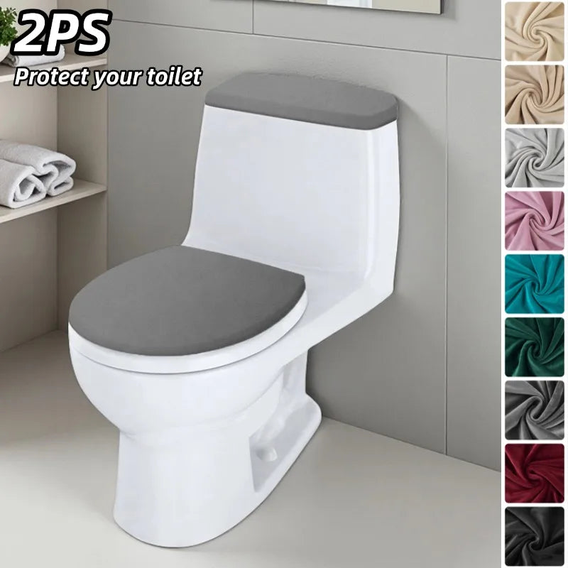A white toilet seat and tank cover set with a gray seat cushion displayed on a light gray cabinet.