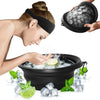 A hand is using a black silicone ice face mask bowl with a built-in tray to apply ice to the face.
