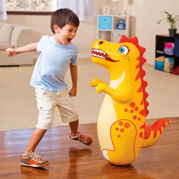 A yellow inflatable dinosaur standing boxing punching bag is positioned on a wooden floor.