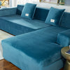 A deep teal plush velvet elastic sofa cover is shown on an L-shaped sofa with decorative throw pillows.