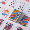 A close-up view of a portable poker playing card deck featuring colorful, patterned cards and a protective box.