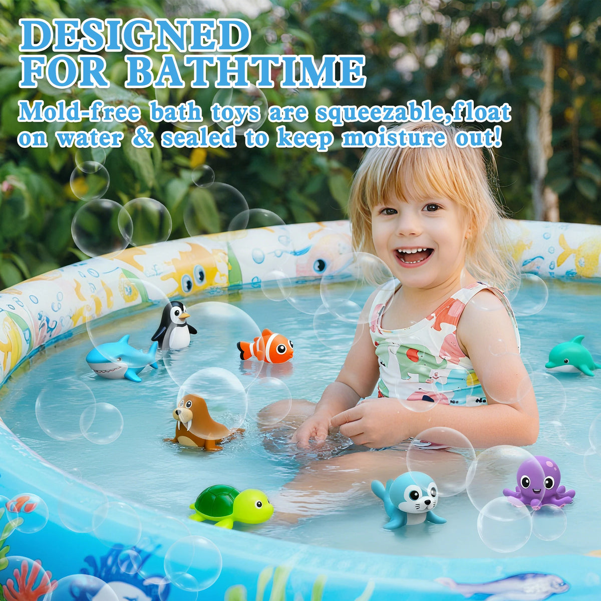 A smiling toddler is playing with an eight-piece mold-free bath toy set in a blue plastic tub filled with water.