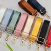 A collection of adjustable nylon bag straps in various colors like blue, green, pink, beige, yellow, and black with gold buck