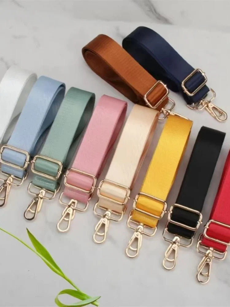 A collection of adjustable nylon bag straps in various colors like blue, green, pink, beige, yellow, and black with gold buck