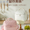 A pink insulated leakproof nylon lunch bag is displayed on a white table, with various utensils and a green fruit bowl nearby