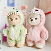 Two plush teddy bears wearing dinosaur jumpsuit outfits, one green and one pink.