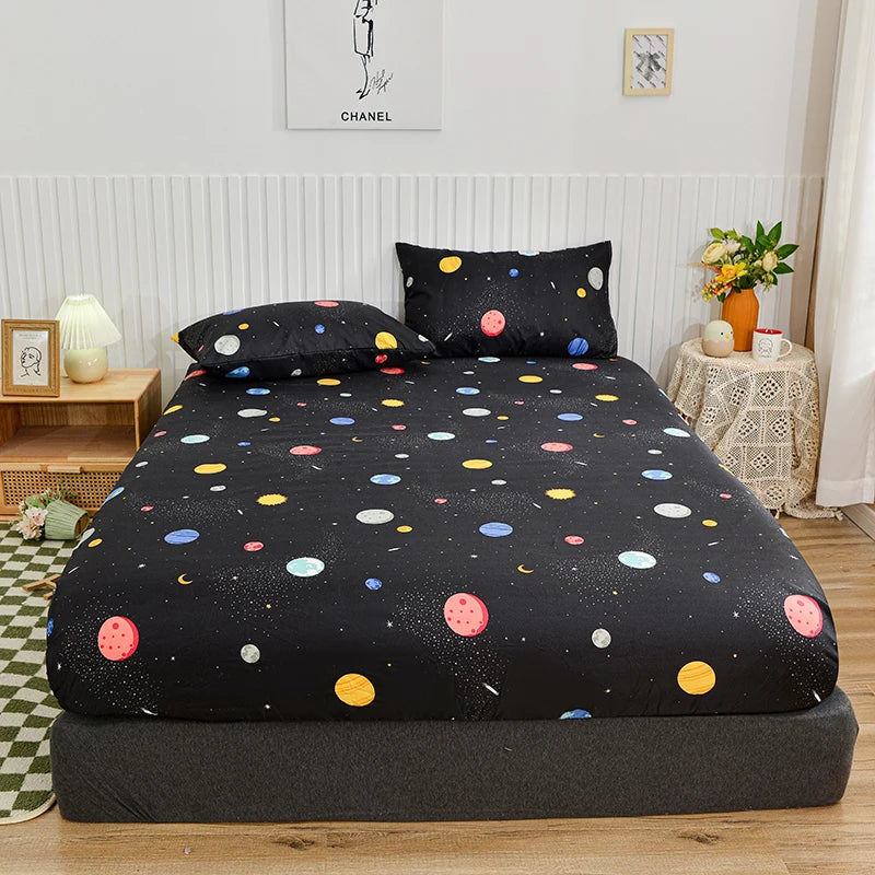 Black fitted bed sheet with a marbled print and all-around elastic band displayed on a bed.