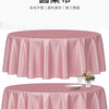 A pink satin tablecloth draped on a round table, featuring pleats and a floral centerpiece.