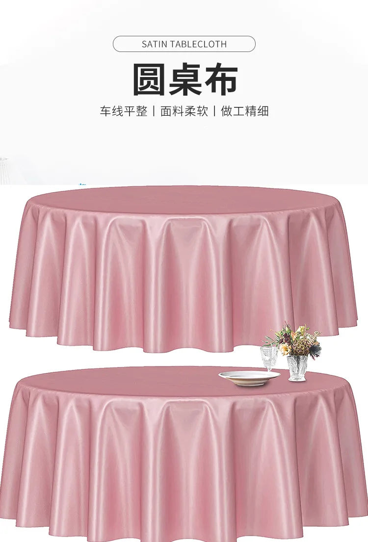 A pink satin tablecloth draped on a round table, featuring pleats and a floral centerpiece.
