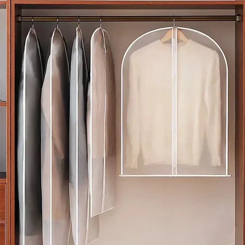 Three transparent zippered garment storage bags hanging in a wooden closet rack.
