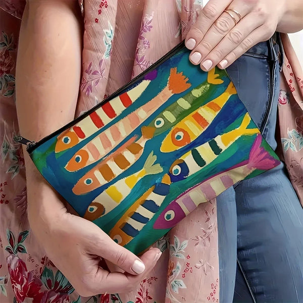 Une main tient un sac de cosmétiques en lin vintage et coloré avec des motifs de poissons peints sur un tissu floral rose.