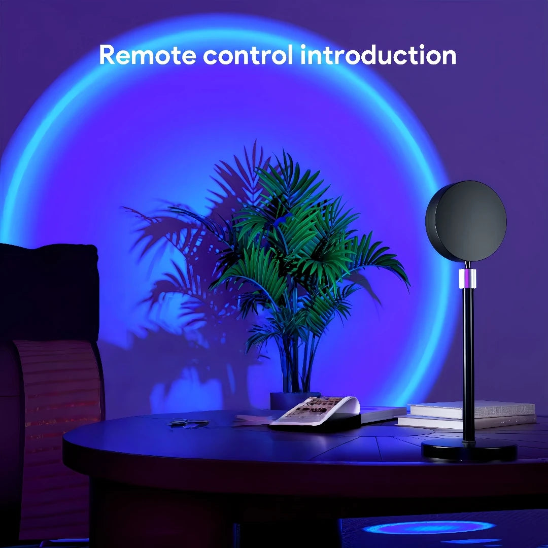 A black sunset lamp projector stands on a table with a green palm plant in the background.