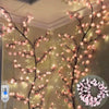 Pink cherry blossom string lights with flower vines decorating a wall.